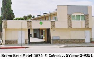 2 story narrow building stone faced entrance portico, seen from US 66. 1958 telephone directory entry added on the bottom.