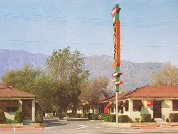1950s Capri Motel, Duarte CA Route 66 color, 1950s hip roof, single story units on both side of drive with trees. Tall neon sign in red and green, Route 66 in front