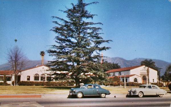 Route 66 and Azusa City Hall 1950s color, 1950s photo postcard lawn in front of Spanish Mission style buildings, City Hall, pine tree, cars. Route 66 running across the image