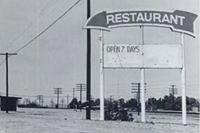 Quinta Scott (c) Kelley’s neon sign thumbnail 1985 black and white Arrow-shaped sign word RESTAURANT on it, right. Left: US66 and truck