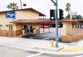 former Desert Inn nowadays San Bernardino motel with gable roof and canopy. 2 stories, cars parked