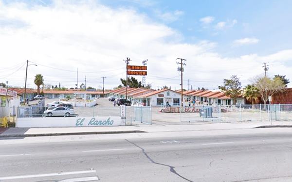 motel, signs, units with gabled roof around courtyard 