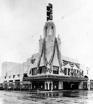 1931 inauguration of Fox Theater, Pomona CA black and white, 1931 theater with tower on a corner draped in flags during its opening