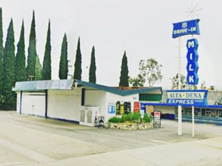 Altadena Googie Style, Glendora color, 2024 Googie styled building with winged roof and neon sign of the early 1960s with blue panels, white letters topped by a star, Altadena Diary store