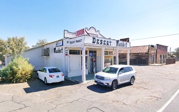 Daggett General Store nowadays US 66 white building, canopy, cars parked, street to the right, a general store