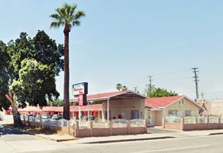 Holiday Inn, nowadays Route 66 San Bernardino corner motel gable roofed, high gabled canopy, palm tree, seen from US66