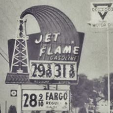 1960s neon sign Nervous Neds Rialto black and white 1960s gigantic oil derrick spewing oil with the words: Jet Flame Gasoline