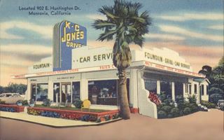 KC Jones drive-in c.1950s Monrovia US66 streamline moderne building box shaped, with blue central pylon over entrance reading in yellow:K.C. JONES DRIVE IN, cars parked, palm tree. Color drawn linnen postcard c.1950s