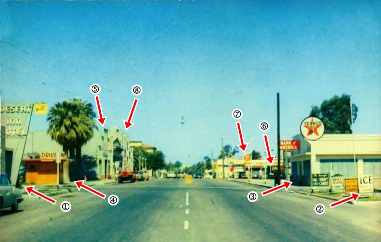 color view of a 1950s avenue with cars parked, buildings, signs of diner, Texaco, motel, bank: Needles CA