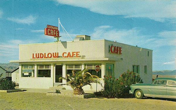 1950s Ludlow Cafe US 66 color 1950s postcard, block shaped white 1 story bldg., LUDLOW CAFE written in red letters on parapet and neon sign abobe it