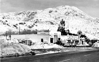Meeker’s building after 1946 black and white Cafe and Texaco, garage in the snow, mountains and US66