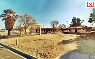2008 color, motel units, trees, office and neon sign US 66 to the left