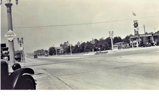 1934 Myrtle and Huntington, Monrovia black and white Moran station (right) Huntington running into the distance, cars, trees, lamp posts 1934.