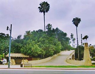 Oaklawn bridge and waiting station, South Pasadena color, concrete bridge right, and small roofed waiting spot left, trees, street runs in front