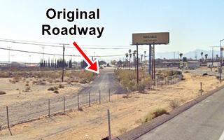 old stretch of highway behind fence seen from modern road