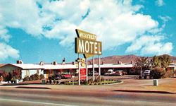 1950s Hillcrest motel US66 Barstow central neon sign, U-shaped layout, gable roof, 1950s cars color postcard of a motel
