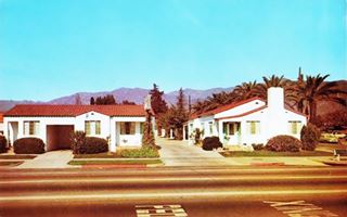 1950s photo postcard, tiled roof units single story facing US 66, mountains beyond, a motel