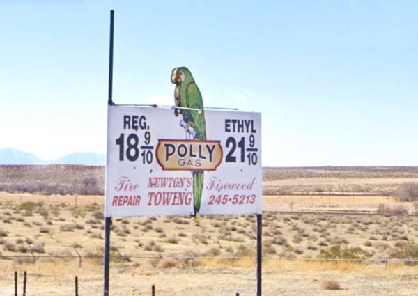 The 1950s Polly Gas station sign in Helendale with green parrott and prices from the 1950s, arid country behind