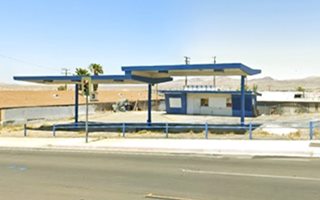 former gas station, two butterfly wing blue canopies by US66, office detached, at the back, vacant