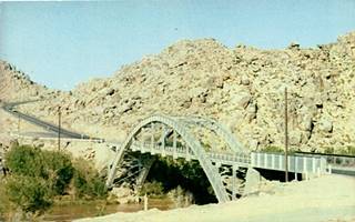 Rainbow Bridge, Victorville arched bridge spanning wooded river in a desert setting, carries a highway