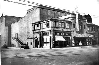 Rialto Theater South Pasadena 1933 black and white photo, 1933, corner with a theater, sign reads RIALTO, cars parked to the left on side street. Flat square marquee, tram tracks run in front