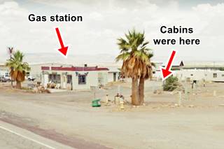 block shaped building, palm trees and US66 running in front, arid sandy area, hills in the distance