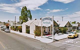 corner building with a sign. Gable roofed