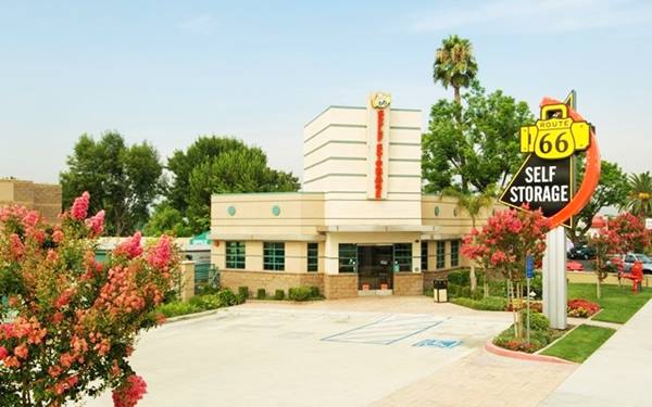 self storage with modern retro-styled neon sign and Streamline Moderne office building using US66 shields; with plants around it seen from US66