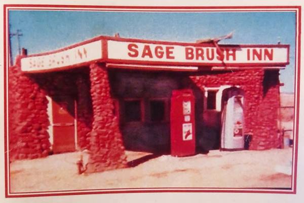 Sage Brush Inn gas station c.1940s US 66 stone building with canopy over vintage pumps, painted red, sign on canopy reads SAGE BRUSH INN c.1940s