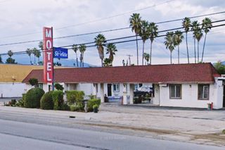 Starlite motel US66 San Bernardino motel, single story, red and wite sign, portico over entrance, palms beyond