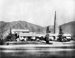 Santa Anita Motor Inn, Rte 66 Arcadia 1941 black and white photo 1941 postcard motel with steeple on the right, modern style, 2 story office. Mountains beyond, highway in front