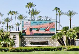 Santa Anita Park racetrack billboard Arcadia CA Rte 66 color, billboard with SANTA ANITA PARK in white letters on its top, shows horse races information and images, palm trees