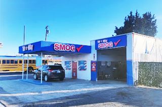 blue and white corner building, car under flat canopy, single service bay, empty pumps island