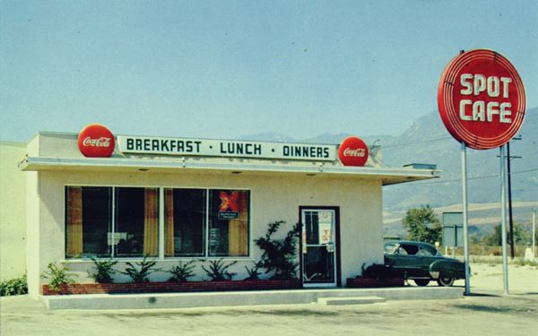 Spot Cafe US 66 San Bernardino c.1950s color postcard, 1950s box shaped flat roof Cafe, red round neon sign reads SPOT CAFE, cars parked, mountains in the distance
