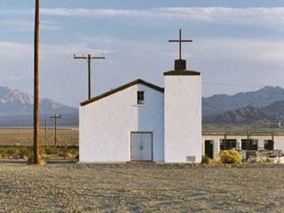 St. Raymond church Amboy austere white church, mountains beyond, desert, gravel drive