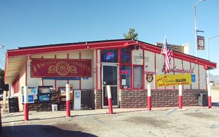 2012 Summit Inn, US 66 Hesperia white woodframe building, 1 story, gable roof, red details, signs. Bricks on lower part of building, a Cafe