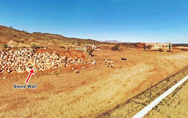 mountains, dirt and arid desert, old retaining wall made of stones and buildings in ruins