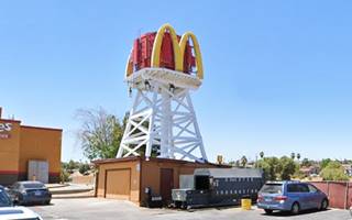 water tank painted red with McDonalds logo in a parking lot, color 2023