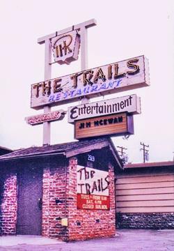 The Trails restaurant US66 Duarte CA color red brick entrance hall of a restaurant neon sign with brand iron symbol atop a panel reading THE TRAILS RESTAURANT, more panels below COCKTAILS, ENTERTAINMENT