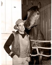 Seabiscuit and Woolf in a stable black and white, Woolf standing by Seabiscuit, thoroughbred horse in a stable