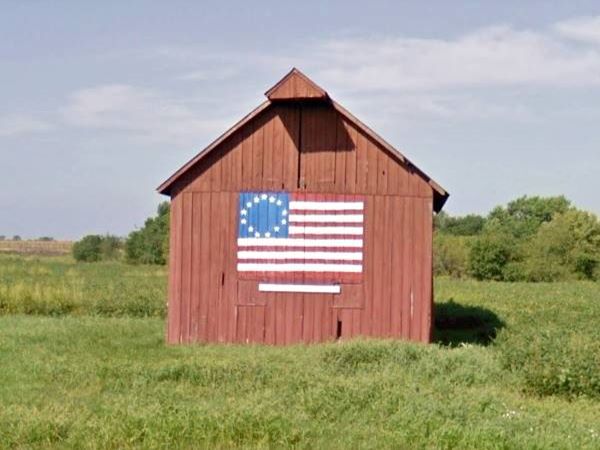 Barn in a field with 13-star flag painted on it in Nilwood Route 66