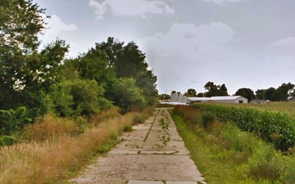 fields and trees and 1920s concrete roadbed sheds in the distance