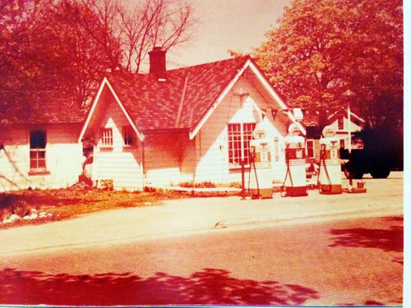 color, faded 1940s photo gable roof woodframe Cities Service station with 3 pumps with glass globes facing Old Route 66