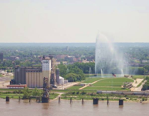 Gateway Geyser in the foreground, the Mississippi beyond, and the Gateway Arch and St. Louis skyline in the background