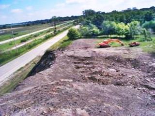 pile of slag by ALT66 in 1999 color, machinery removing slag by ALT 66 seen from the top of the heap