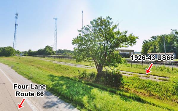 old cracked roadway of US66 (right) and railroad beyond. Tree between roadway and the later alignment of US 66, grassy shoulder