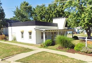 woodframe corner building, flat roof, angled protrusion on facade