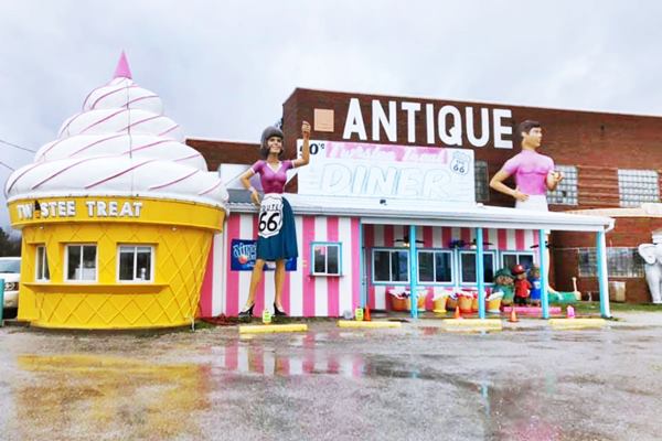 Large fiberglass sculptures and ice cream cone with a vintage diner next to a red brick building