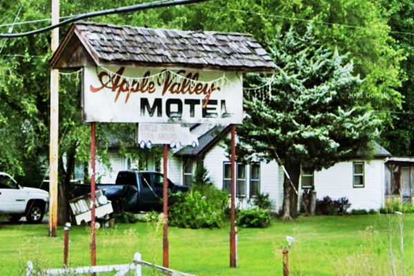 billboard under shingle gable tiny roof with words "Apple Valley motel" written on it