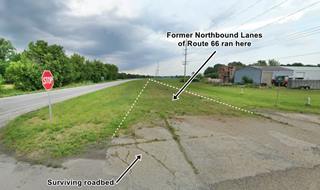 color, highway left, trees, buldings right, shoulder is grassy and wide, former Northbound lanes ran here, concrete roadbed can be seen